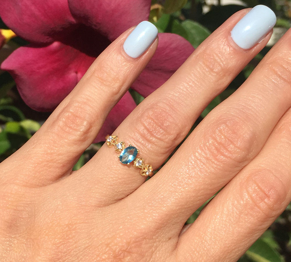 Blue Topaz Ring - December Birthstone - Delicate Ring with Oval Blue Topaz Gemstone and Flower Setting with Clear Quartz Accents - H.L.Jewelry