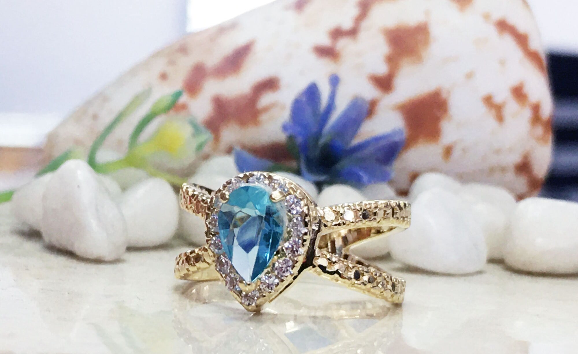 Blue Topaz Ring - December Birthstone - Statement Engagement Ring with Pear-Shaped Blue Topaz Gemstone and Clear Quartz Halo - H.L.Jewelry