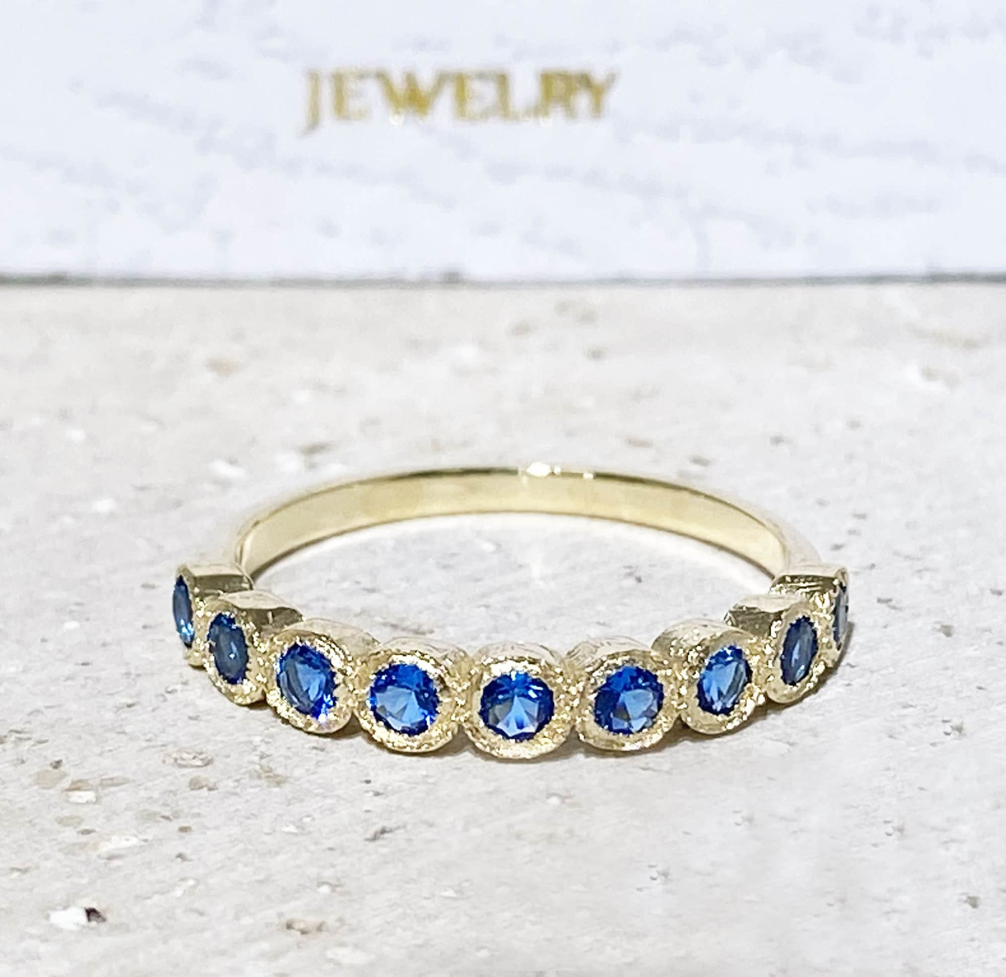 Blue Topaz Ring - December Birthstone - Delicate Stacking Half Eternity Ring with Nine Round Blue Topaz Gemstones - H.L.Jewelry