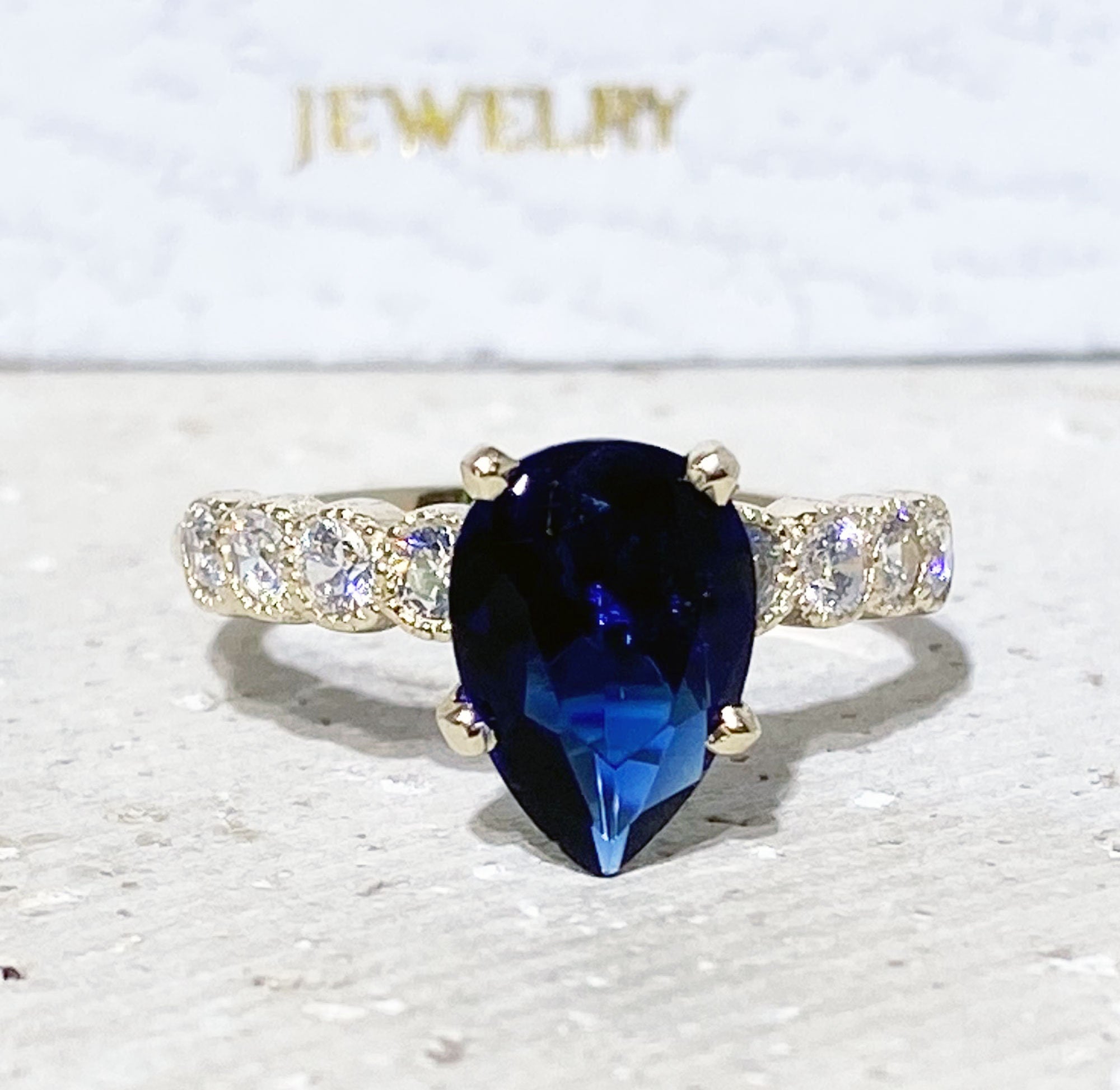 Blue Sapphire Ring - September Birthstone - Statement Engagement Ring with Pear-Shaped Blue Sapphire Gemstone and Clear Quartz Accents - H.L.Jewelry